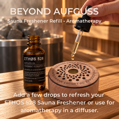 A hand holds a glass dropper above an amber bottle and a round wooden diffuser base labeled ETHOS 528. Large text reads 'BEYOND AUFGUSS' and 'Add a few drops to refresh your ETHOS 528 Sauna Freshener or use for aromatherapy.